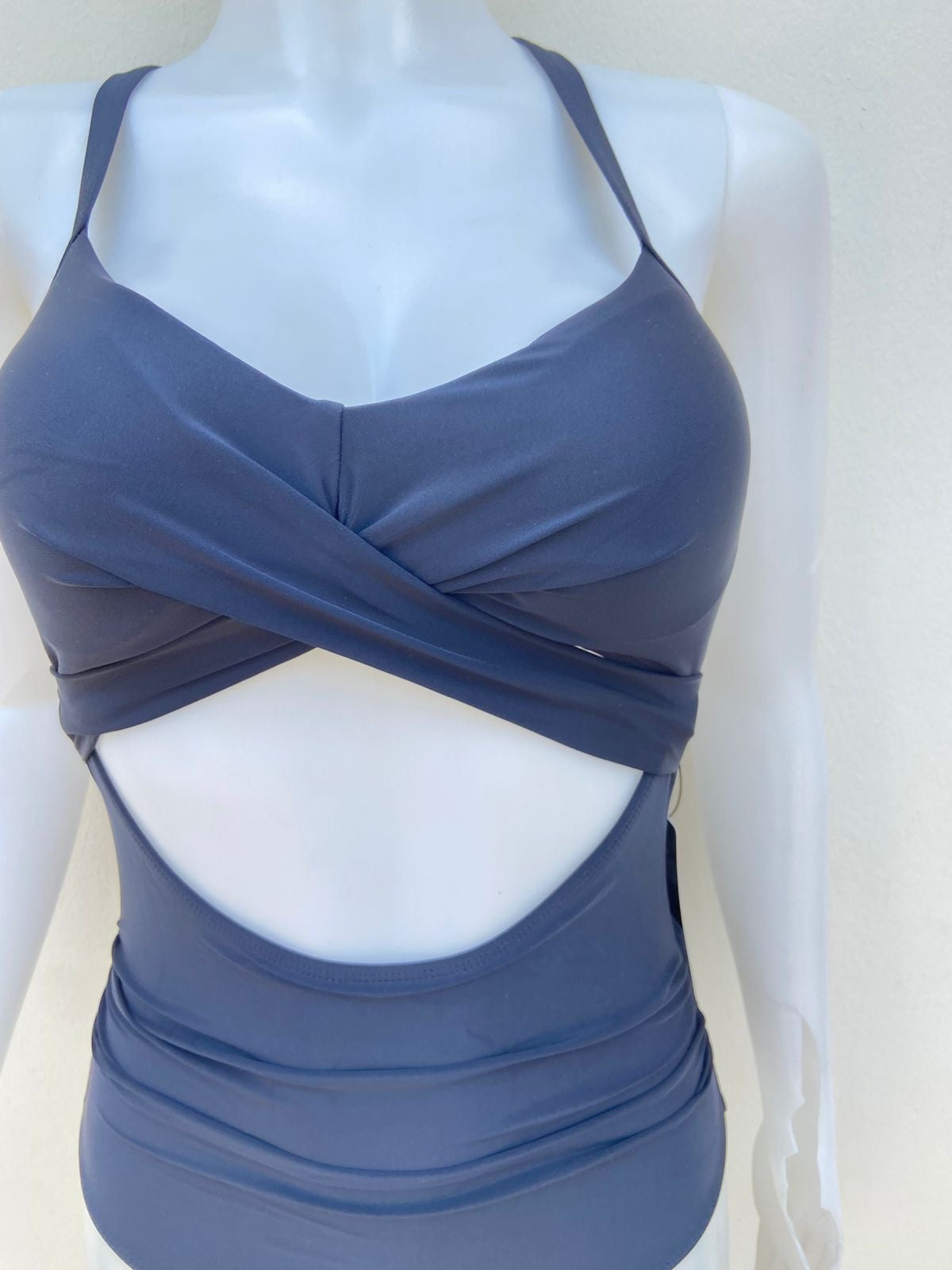 Biquini, negro liso con lazos ajustables en la eslpada y abierto en la parte delantera, una pieza.