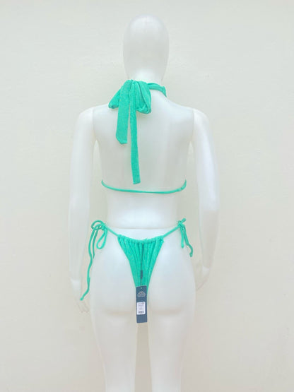 Biquini, de una pieza  verde con diseño de brillos y lazos ajustables.