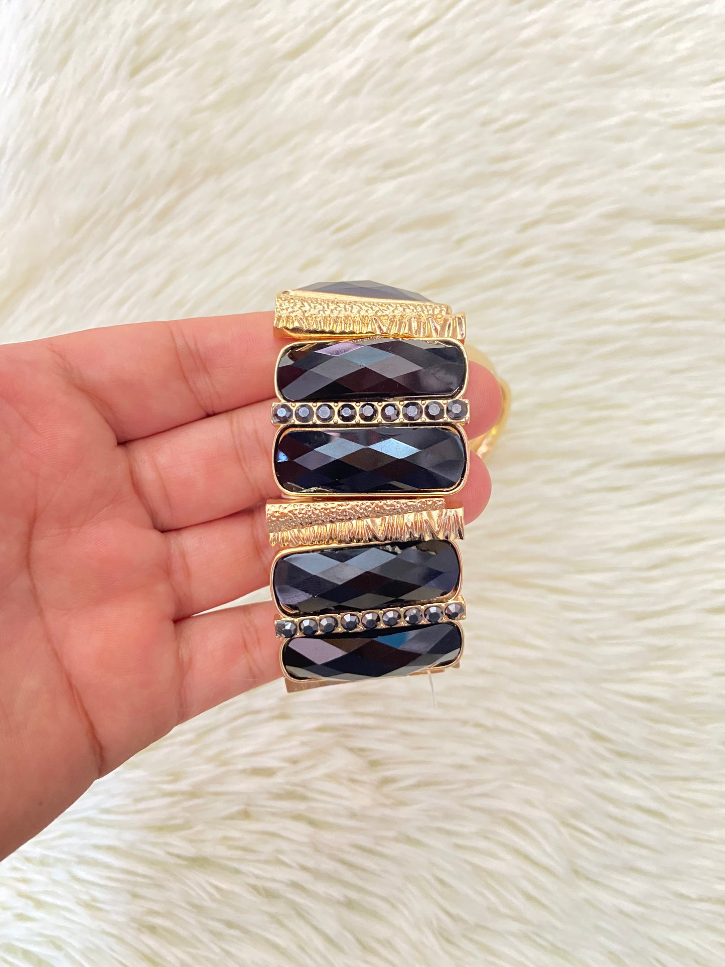 Set de pulseras una en color dorado con detalles plateados y otra con Piedras grandes negras y doradas.