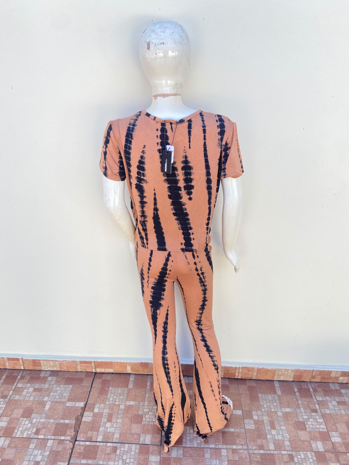 Conjunto de niña en color marron con estampado de líneas en color negro, Legging y top.
