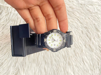 Reloj Casio original negra con fondo en color blanco y verde.