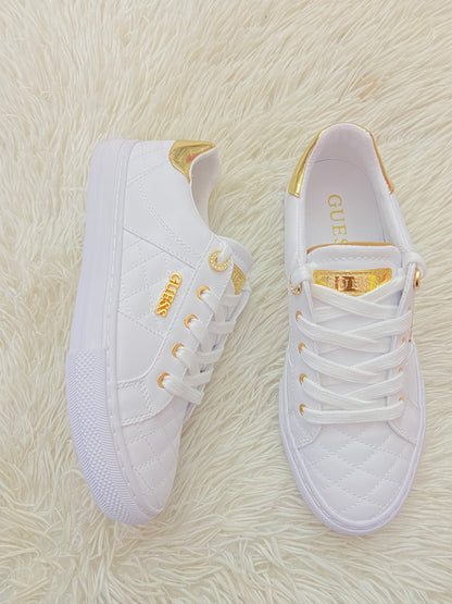 Tenis GUESS original blanco con detalles en color dorado y placa GUESS en dorado.