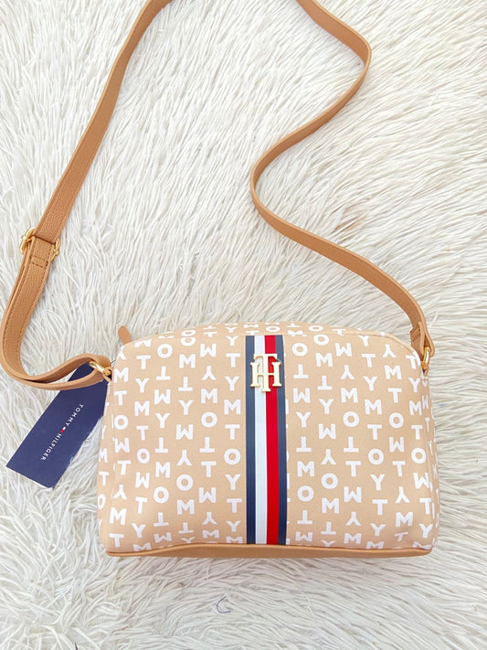 Cartera TOMMY HILFIGER original crema con estampado de letras TOMMY y banda de color rojo, azul y blanco y placa TH en dorado.