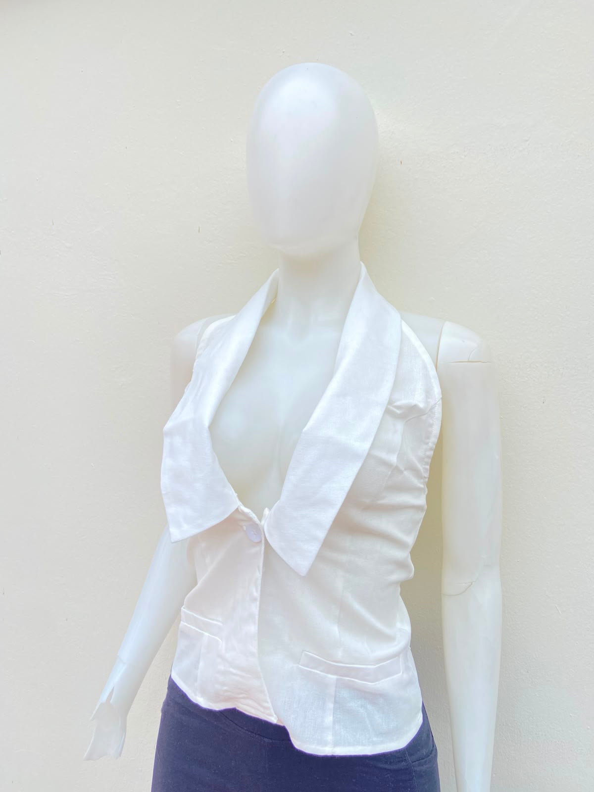 Top blanco con cuello estilo camisa, descostado atras.
