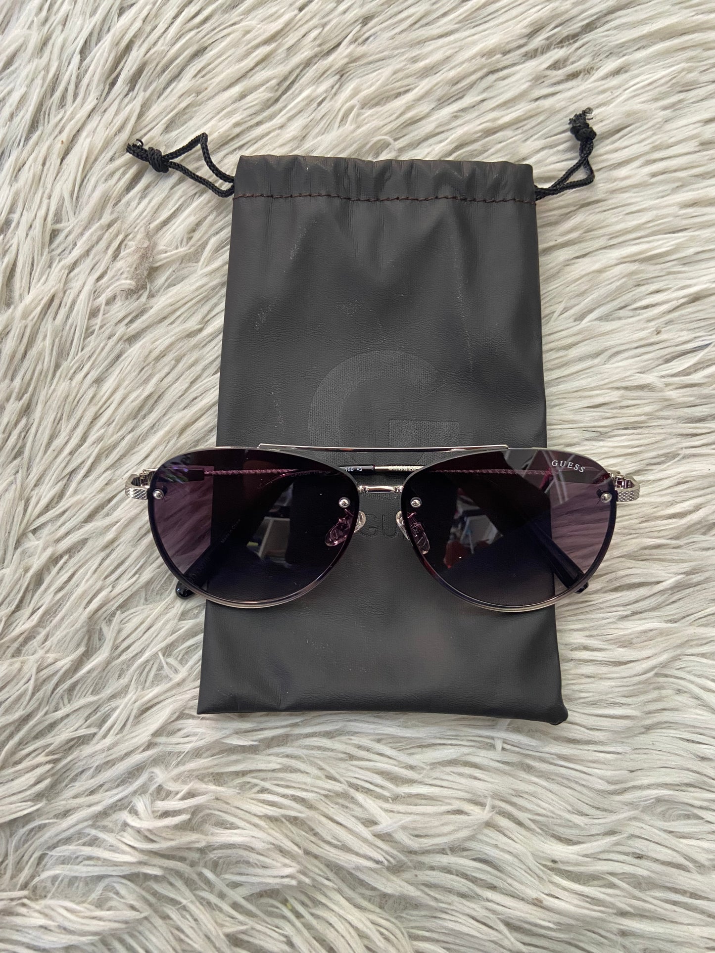 Lentes GUESS Original con marco plateado, letra guess al frente, micas grandes y con degradado morado oscuro.