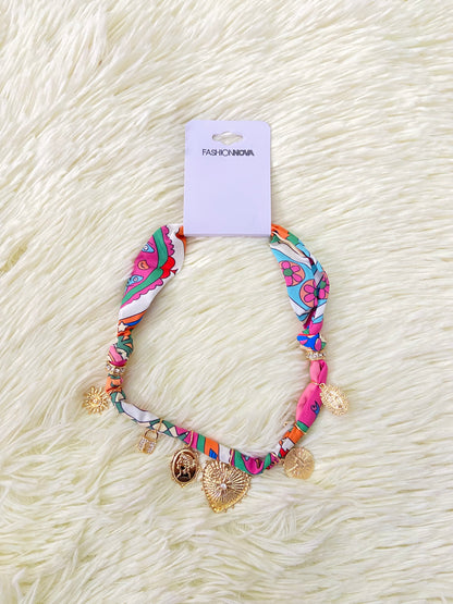 Collar de paño con accesorios colgantes de sol, corazones, la virgen entre otras.