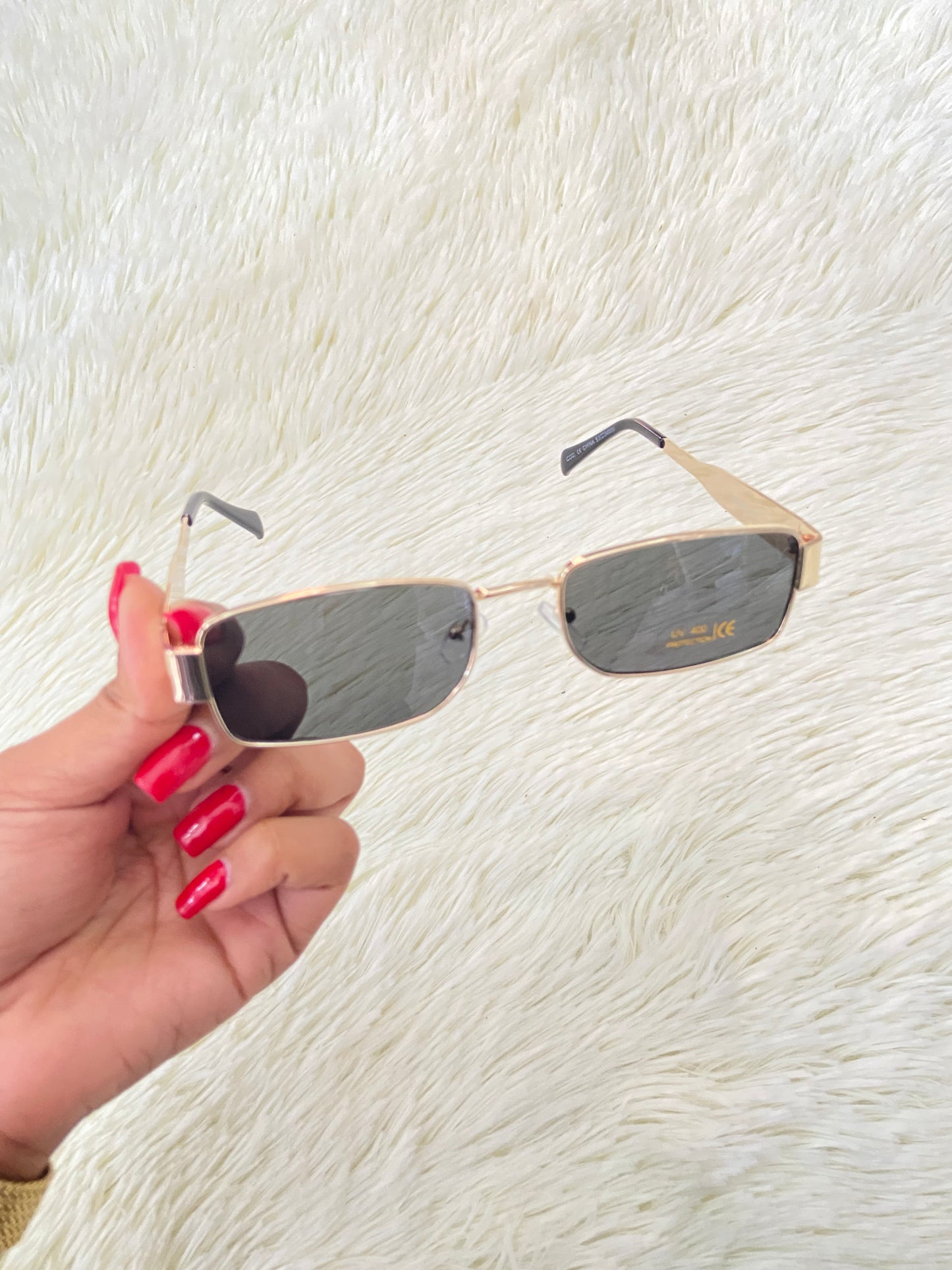 Lentes, negros con montura en color dorado, pequeños con protección UV 400.