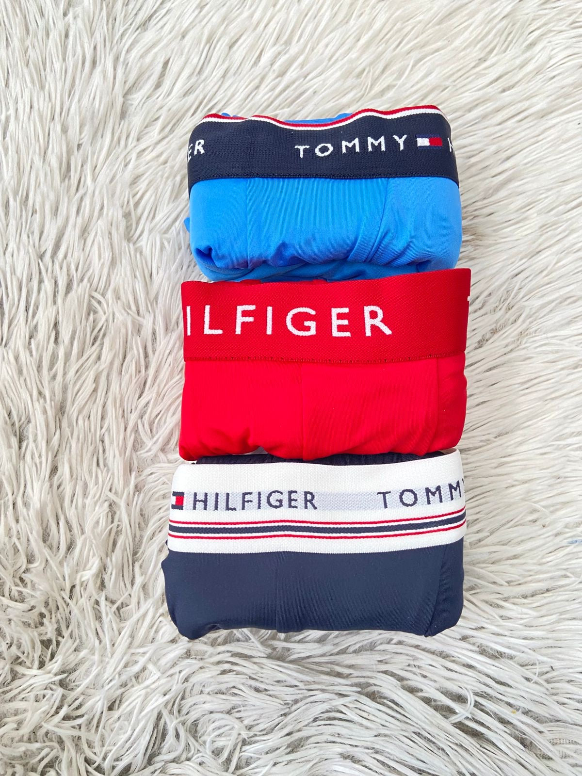 Pack  Boxers Tommy Hilfiger original, rojo, azul claro y azul marino con letras TOMMY HILFIGER en blanco.