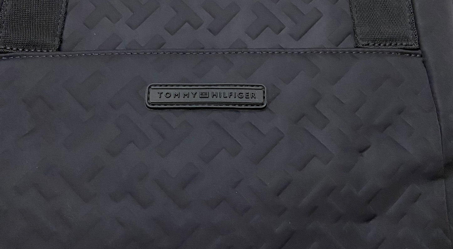 Cartera Tommy Hilfiger original negra con estampado de la marca Th y letras TOMMY HILFIGER en frente.