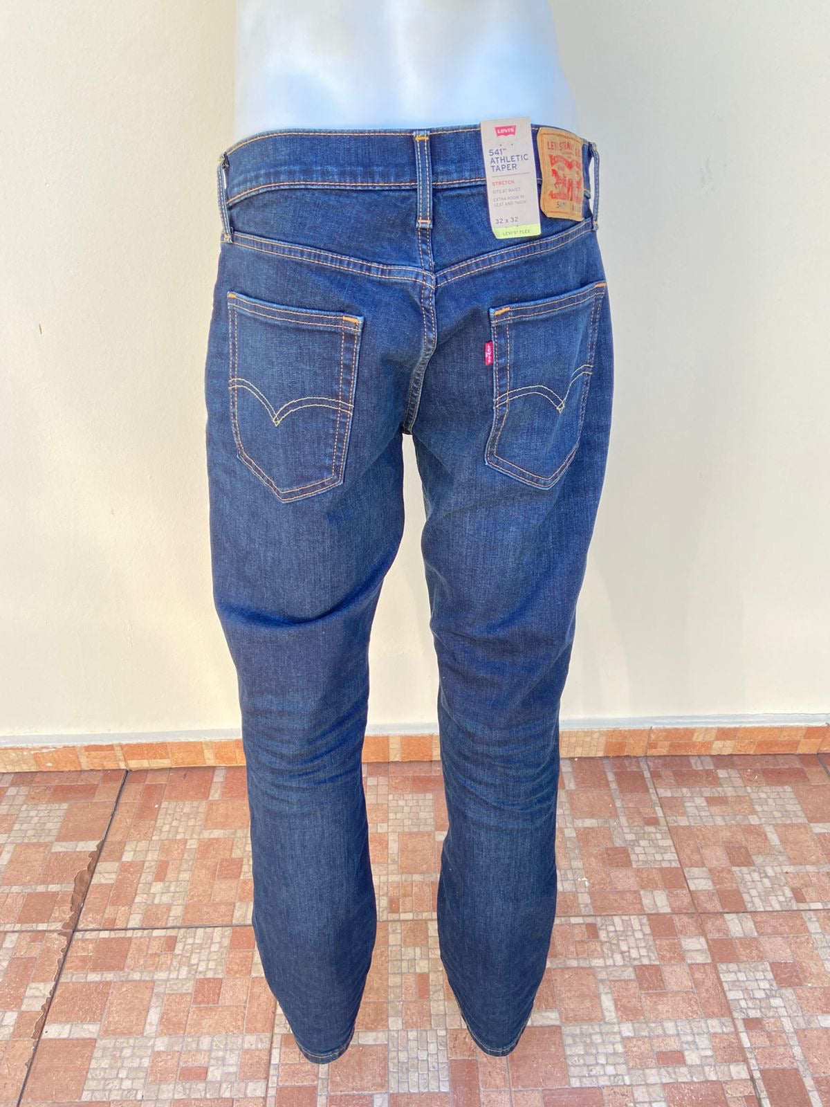 Pantalón Jean Levi’s original, azul oscuro liso, con costura en hilo marrón.