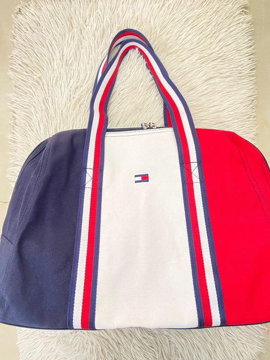 Bulto Tommy Hilfiger Original en color azul marino blanco y rojo con logotigo de la marca al frente