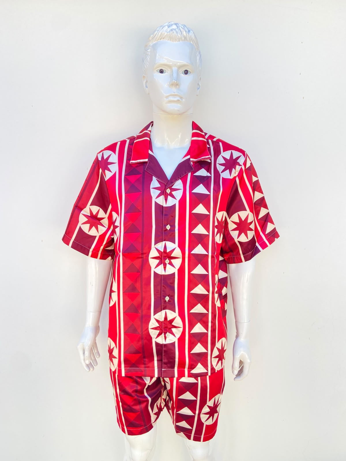 Conjunto, rojo con estampado de figuras en color crema, de Bermuda y camisa.
