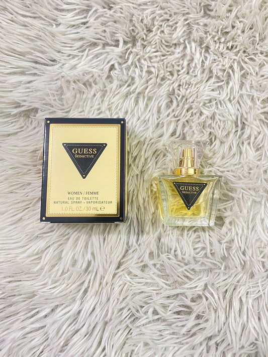 Perfume Guess SEDUCTIVE original, dorado con logotipo de la marca Guess en negro.