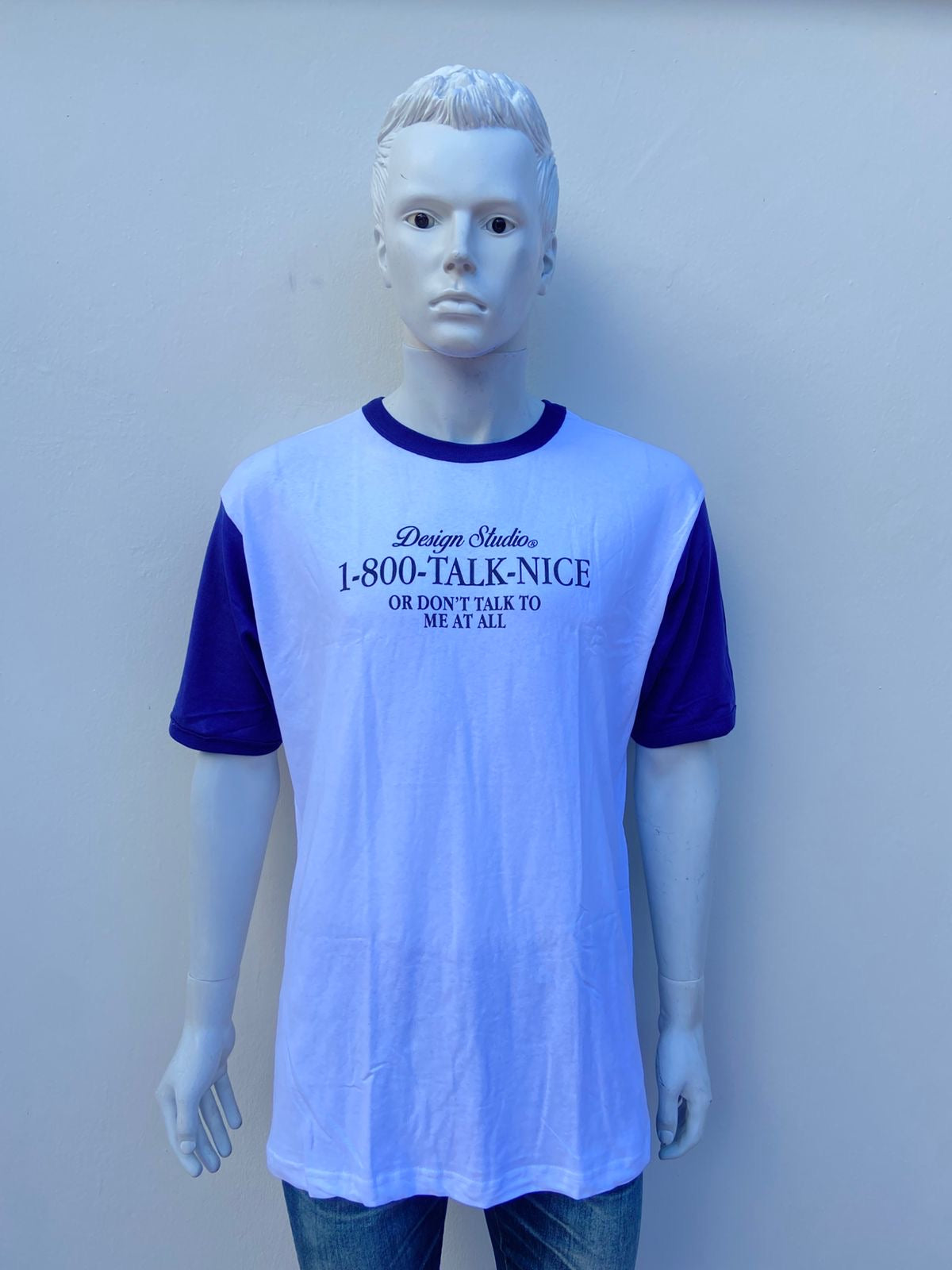 T-shirt blanco con mangas y cuello azul marino y letras negras al frente DESIGN STUDIO 1-800-Talk-Nice