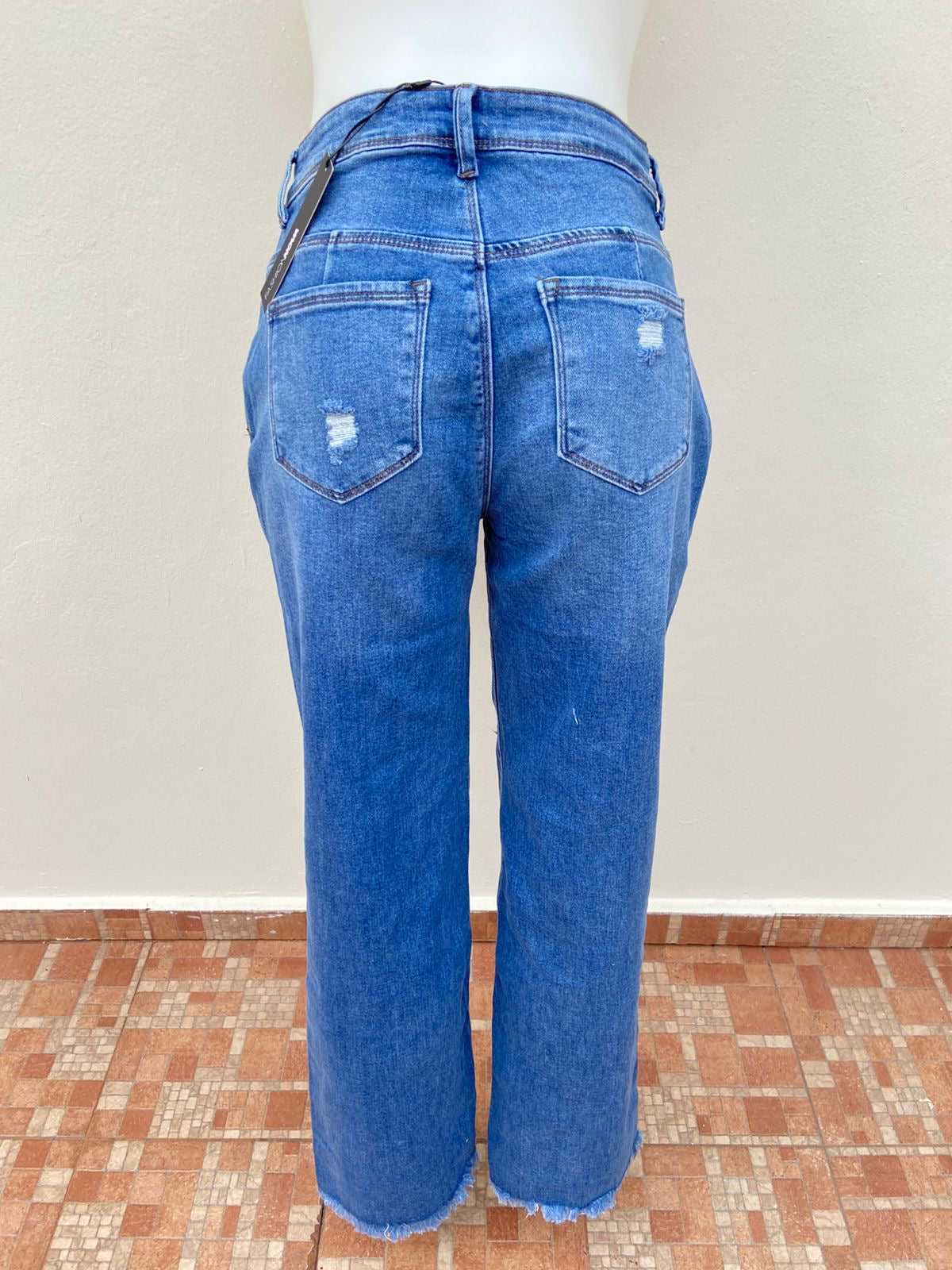 Pantalón Jean, azul con rasgados en la parte delantera y los bolsillos traseros.