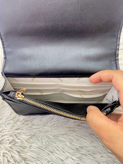Cartera BEBE Original, negro con nombre de la marca al frente en color dorado, correa tipo cadena enlazada con tela negra.