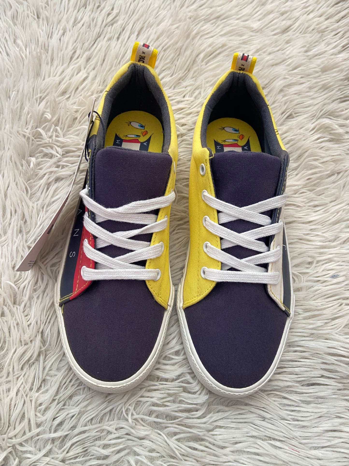 Tenis Tommy Hilfiger original con parte del frente en color negros lado de adentro en amarillo y a los lados con logo TOMMY letras JEANS en blanco y diseño de PIOLIN