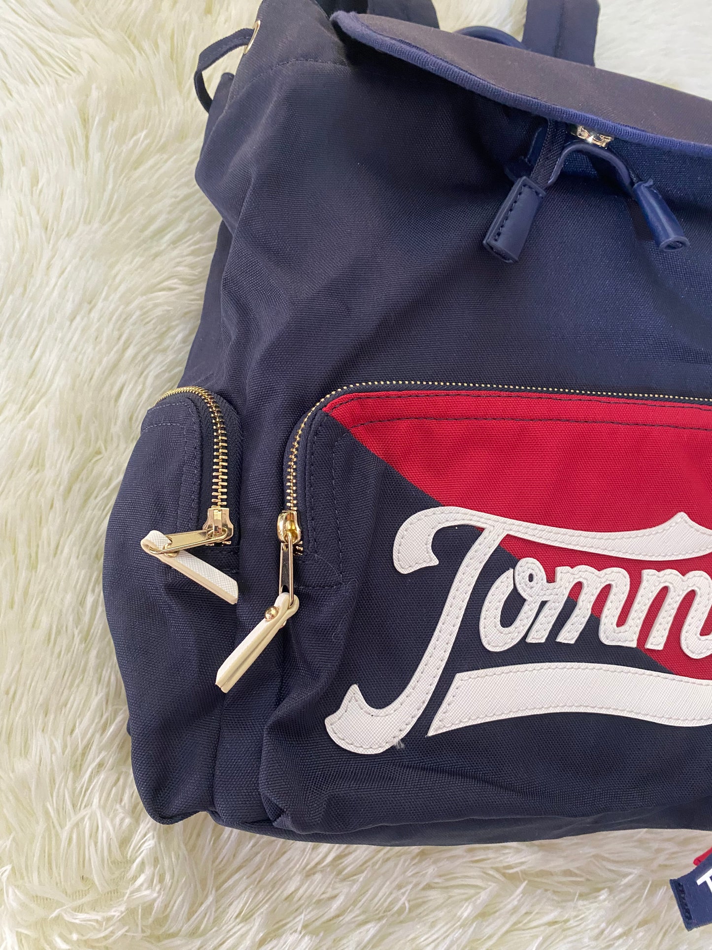 Mochila Tommy Hilfiger original en color azul marino, nombre TOMMY en grande en un bolsillo con el fondo rojo, varios compartimentos, súper espacioso.