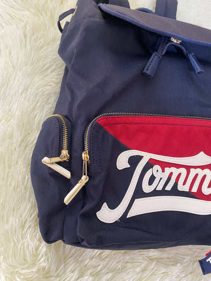 Mochila Tommy Hilfiger original en color azul marino, nombre TOMMY en grande en un bolsillo con el fondo rojo, varios compartimentos, súper espacioso.