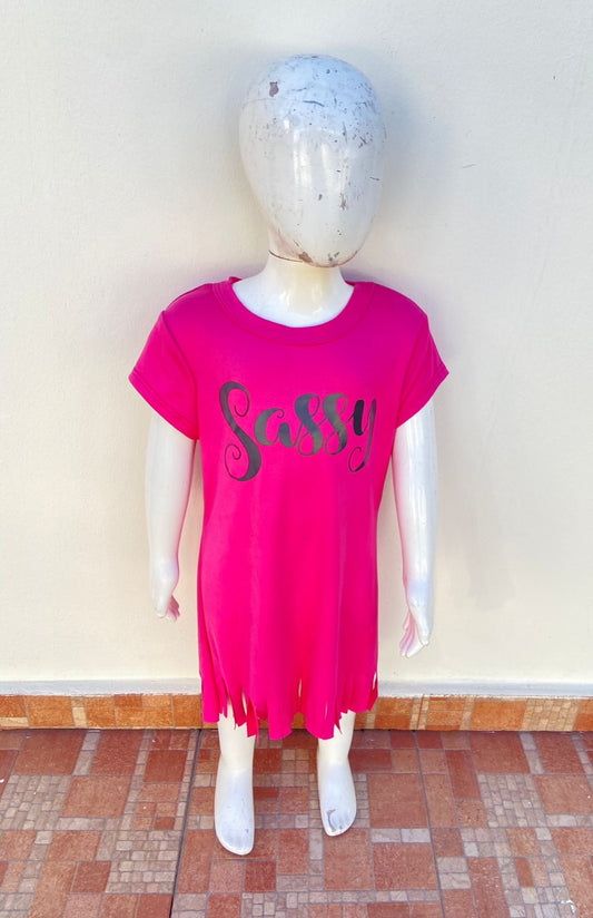 Vestido, rosado fucsia con letras SASSY ( atrevida )en negro y tiras en la parte inferior.