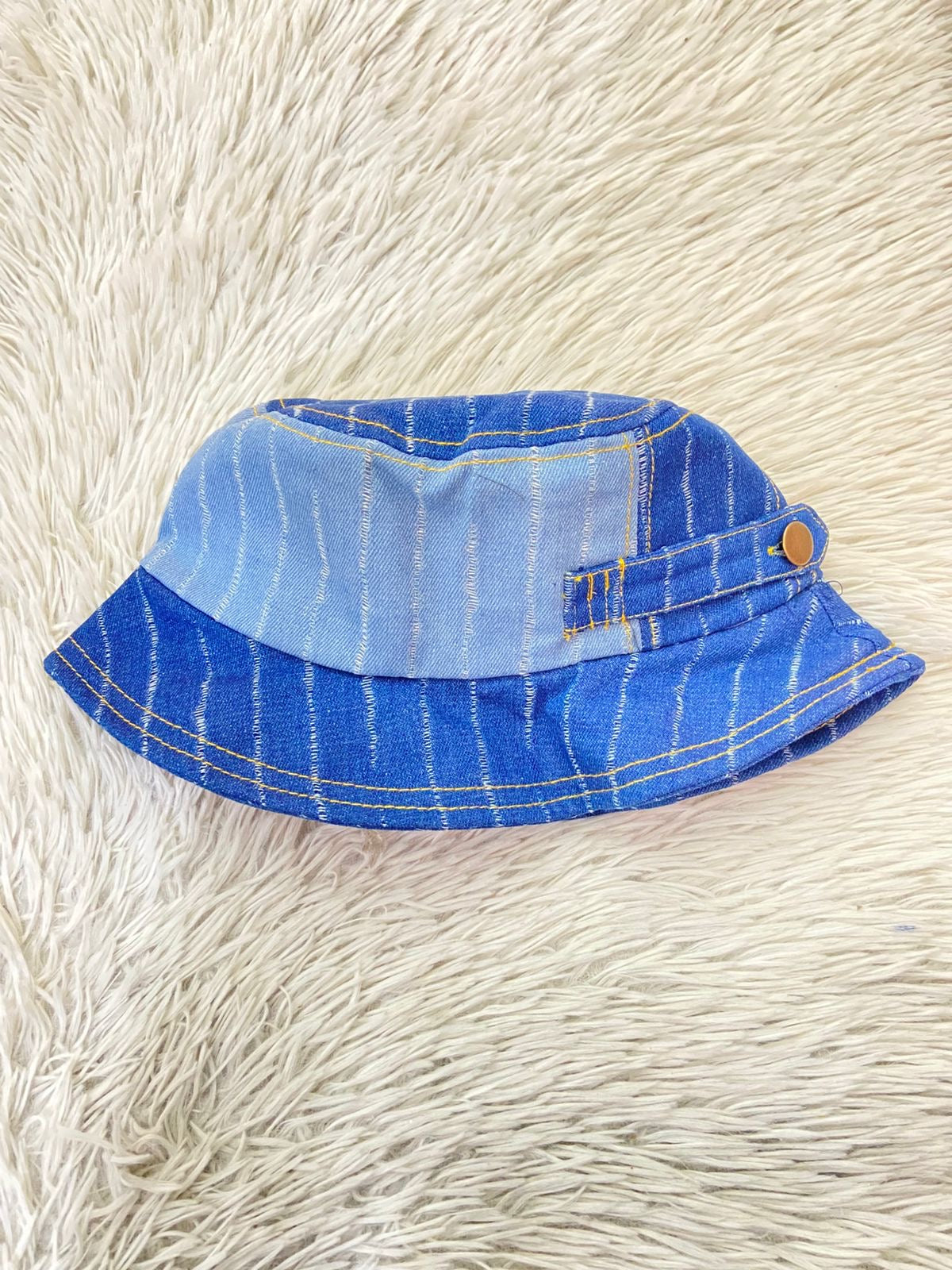 Gorro en tela jean con dos tonos diferentes en boton al lado