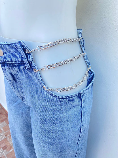 Pantalon jean ancho con degradado blanco y detalle de cadenas en los lados en color pletadas.
