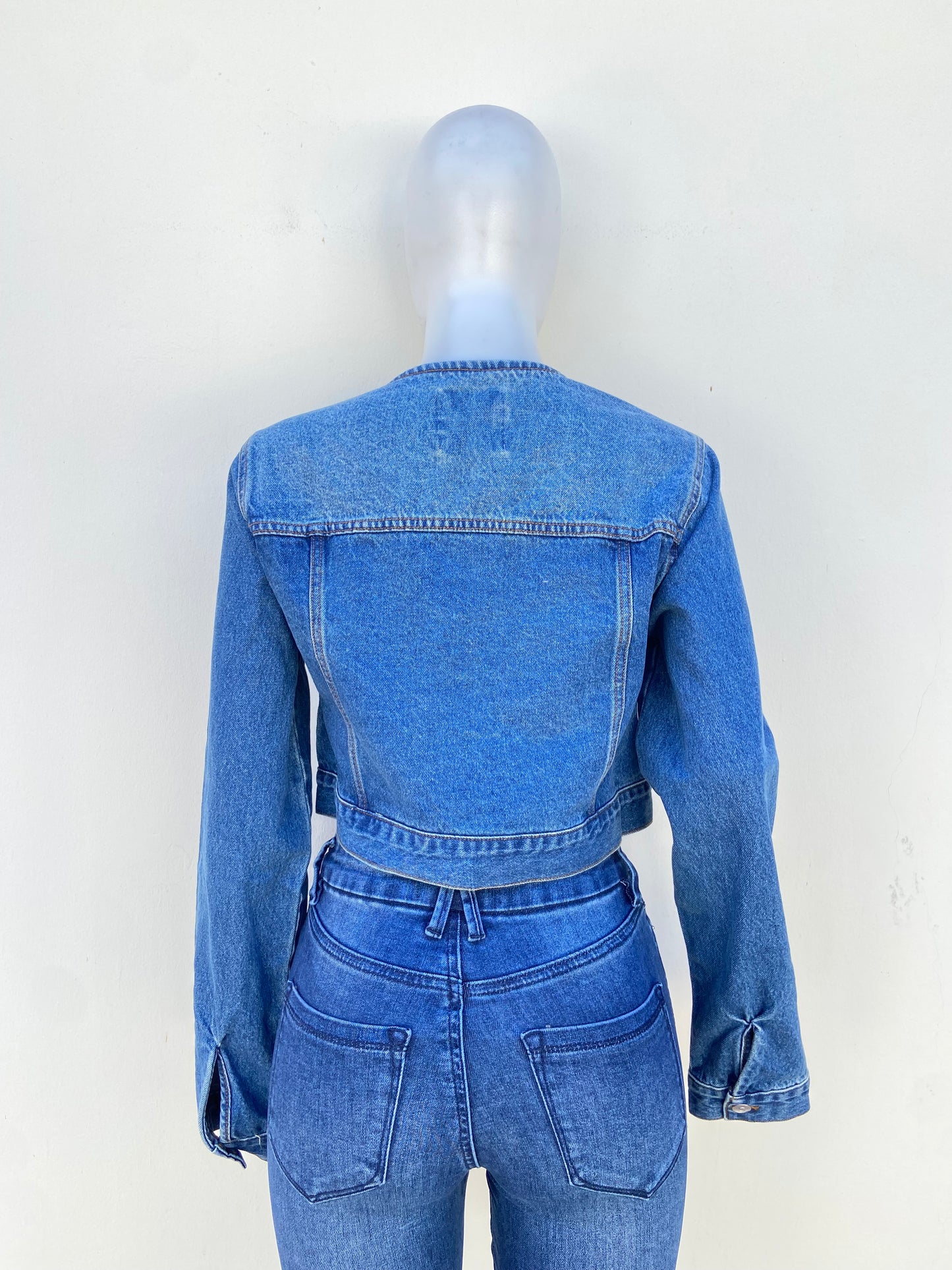 Caqueta, azul marino en jean con botones en frente.