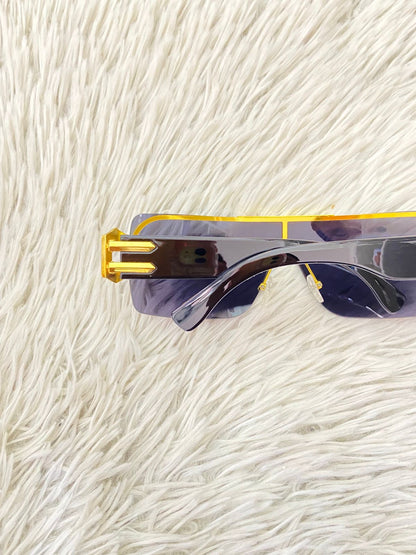 Lentes con protección UV 100-400 para proteger tu visión. En color negro con detalles dorados en los lados.