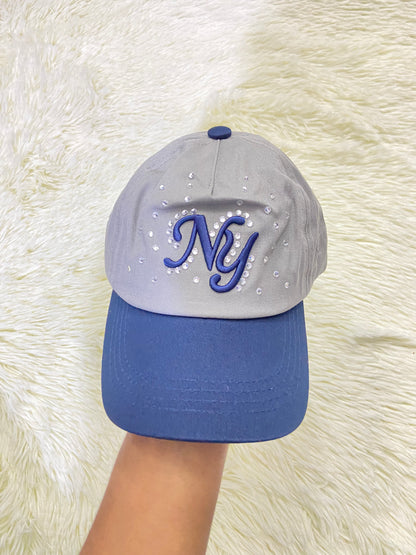 Gorra, gris con azul marino y letras NY y detalles de diamantes, para niños.