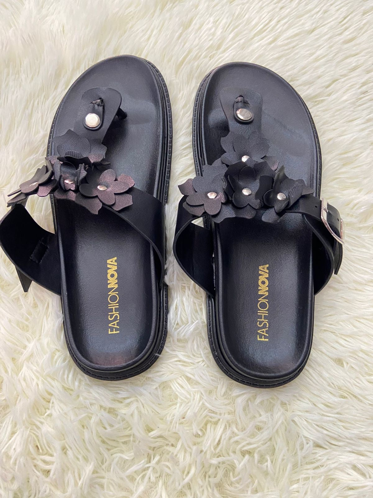 Sandalias, negra con flores en frente y correa ajustable.