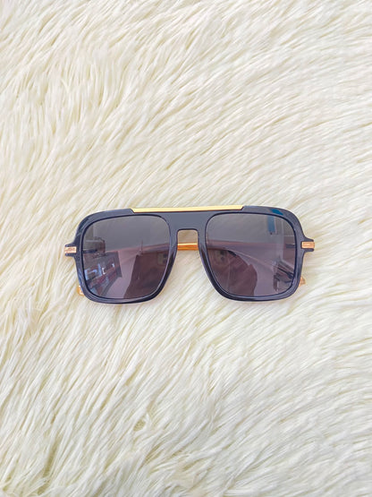 Lentes, negros con detalle dorado al frente y patillas doradas.