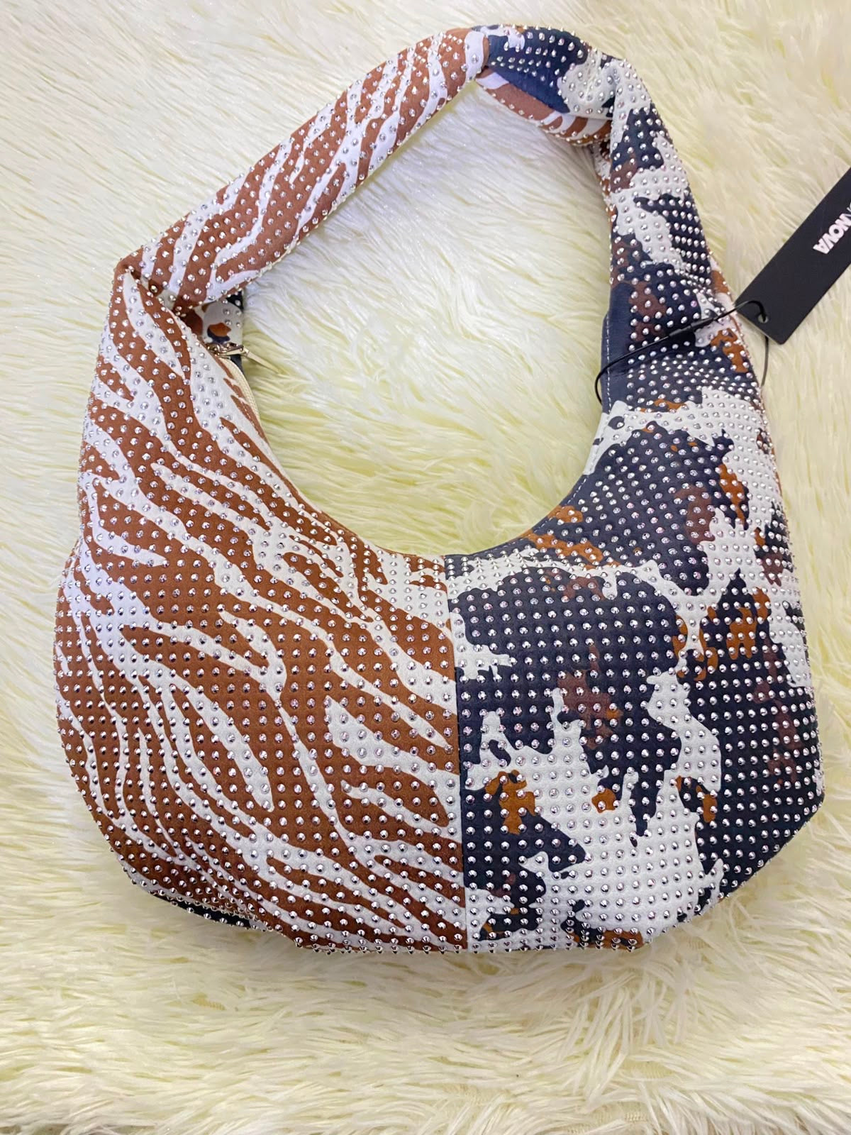 Cartera, color blanco con marron y estampado de animal print y detalles de piedras.