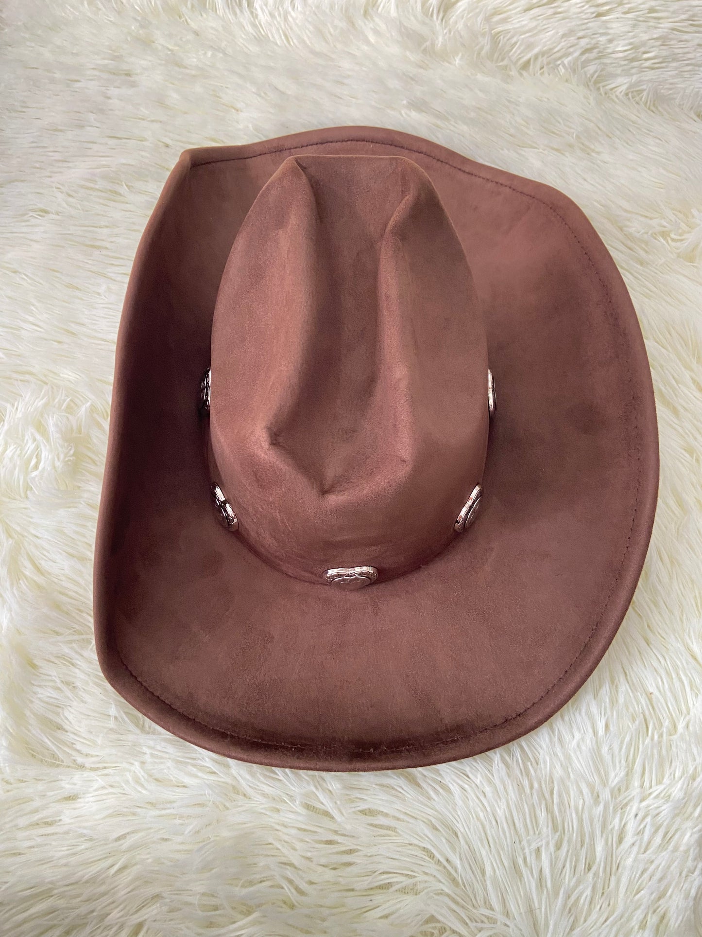 Sombrero, marron oscuro con placas de corazón al rededor en plateado, estilo vaquero.
