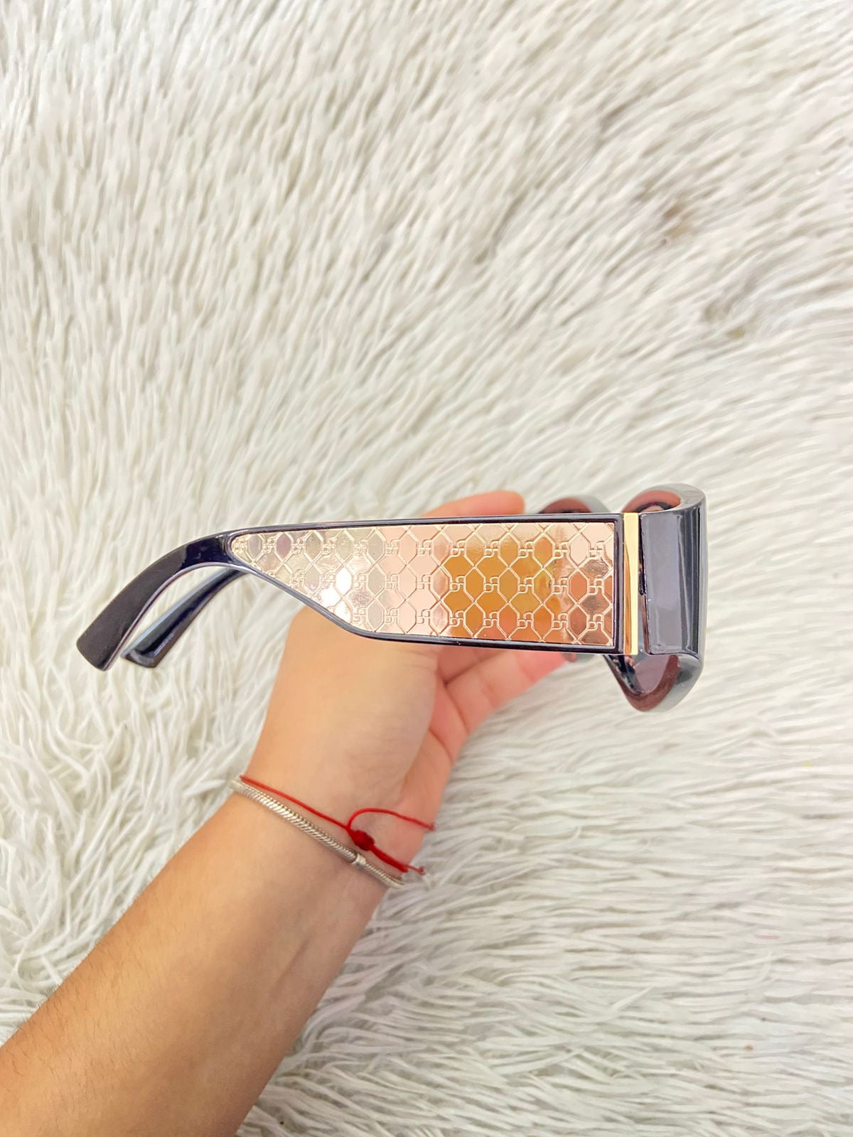 Lentes negros con detalles en color dorados y micas oscuras