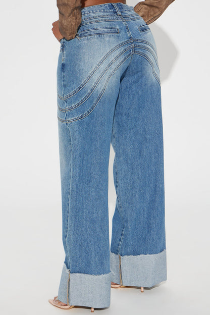 Pantalon jean azul con deslavado medio, detalle de algunas salpicaduras en color blanco, costuras decorativas alante y atras y doblado abajo.