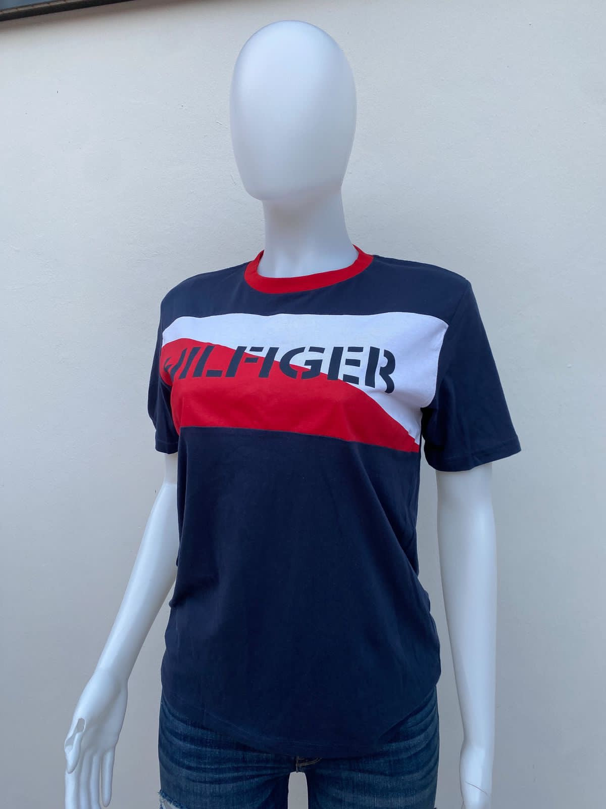 T-shirt Tommy Hilfiger original azul marino con letras HILFIGER en azul marino y rayas roja y blanca.