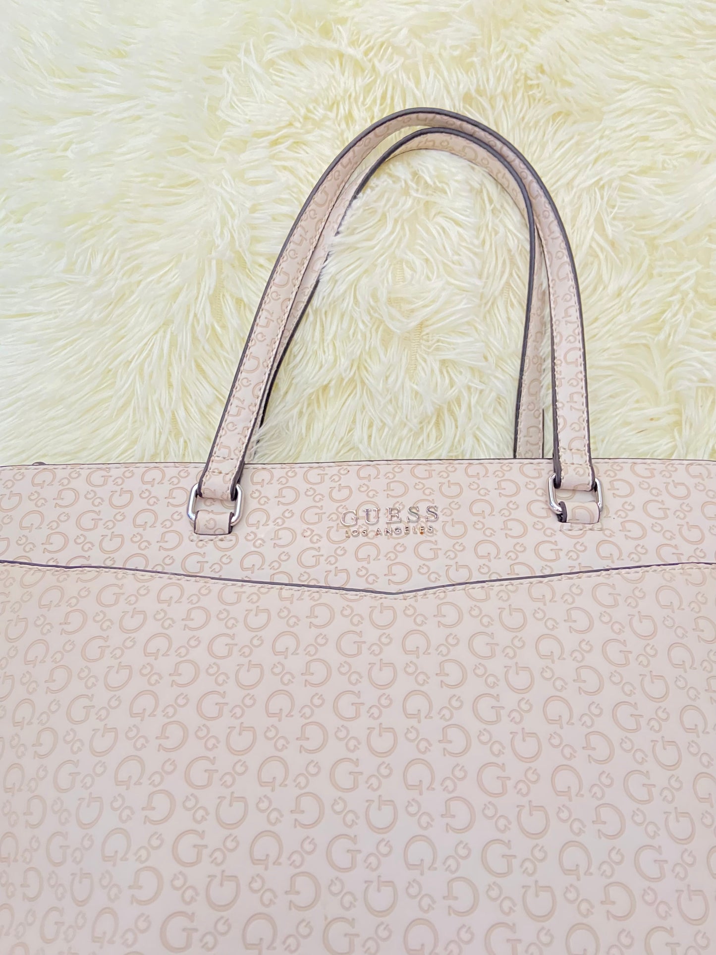 Cartera GUESS original, grande, rosado palo crema con letras G y placa GUESS en plateado en frente.