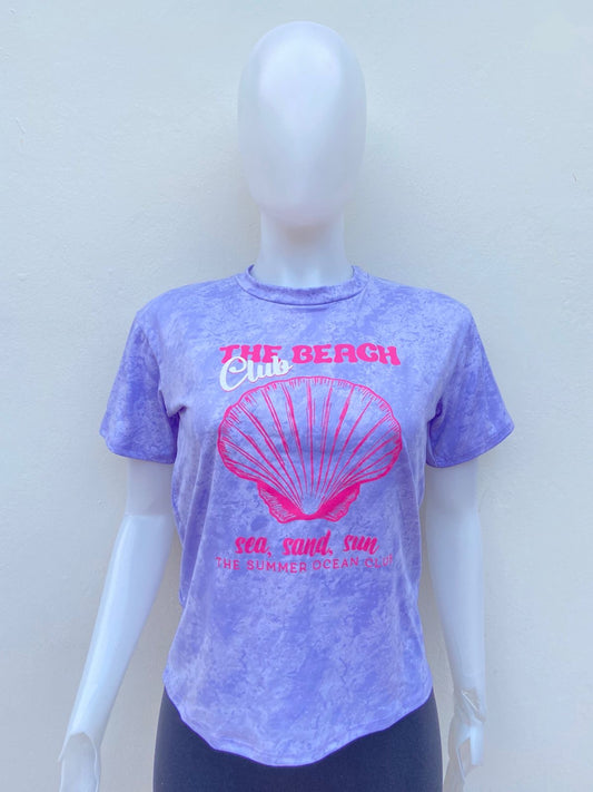 T-shirt, morado lila con blaco y estampado de una concha marina en color rosa y letras THE BEACH CLUB.