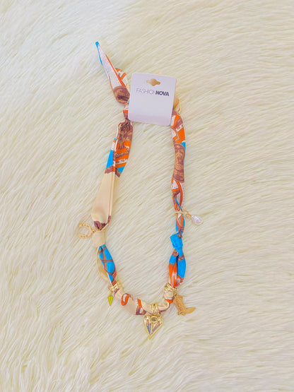 Collar de paño con accesorios colgantes de perlas, corazones y zapatos de vaqueros.