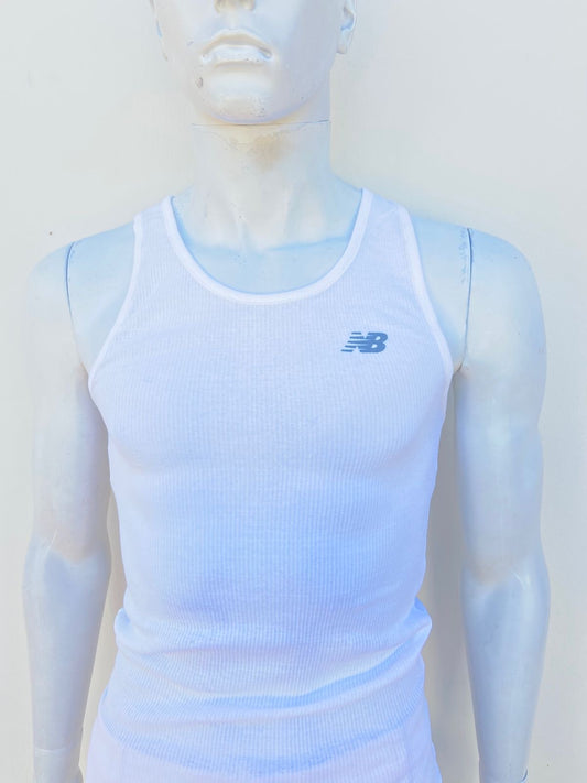 Franela New Balance en color blanca con logotigo de la marca al frente en color gris.