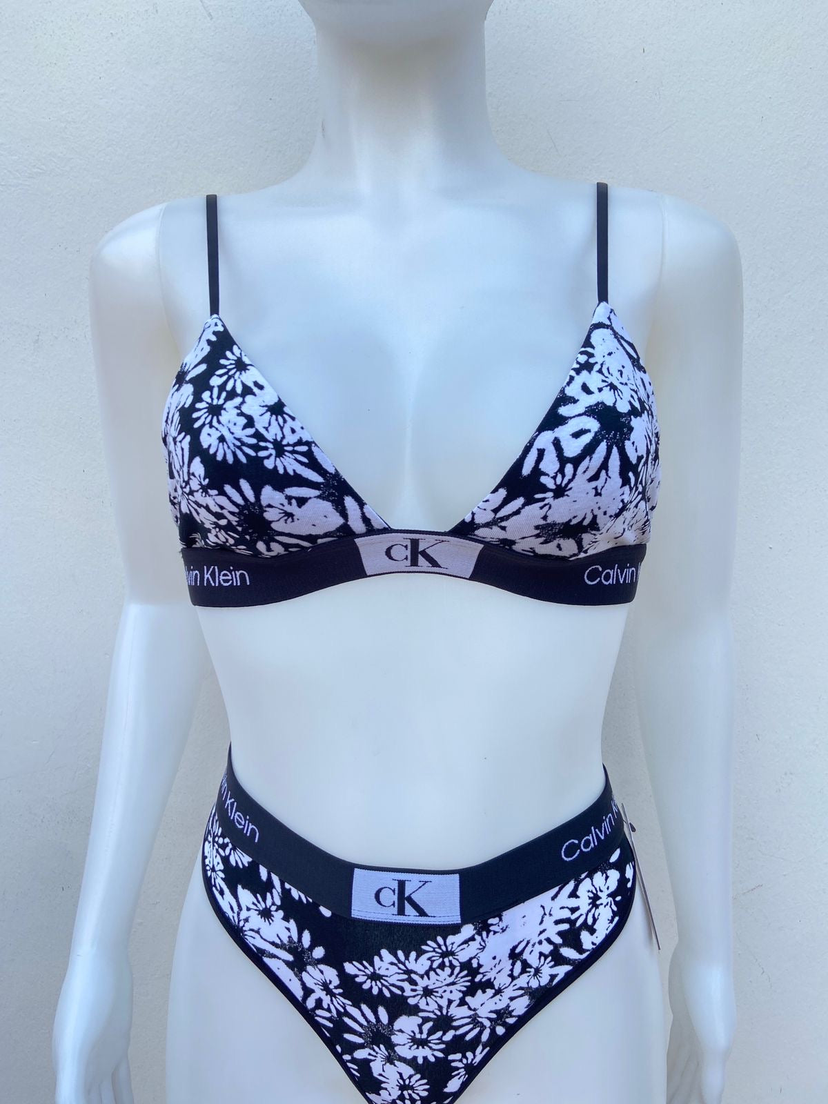 Conjunto Calvin Klein original, negro con blanco Panti tanga y brasier con estampado de rosa y cK en el centro.