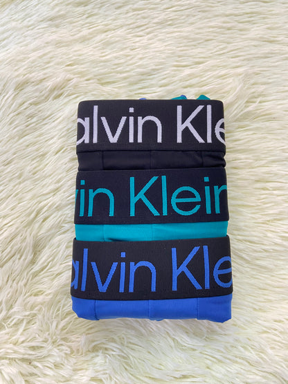 Pack-3 Boxer CALVIN KLEIN original, azul, verde Aqua y  negro con letras de la marca en la pretina.