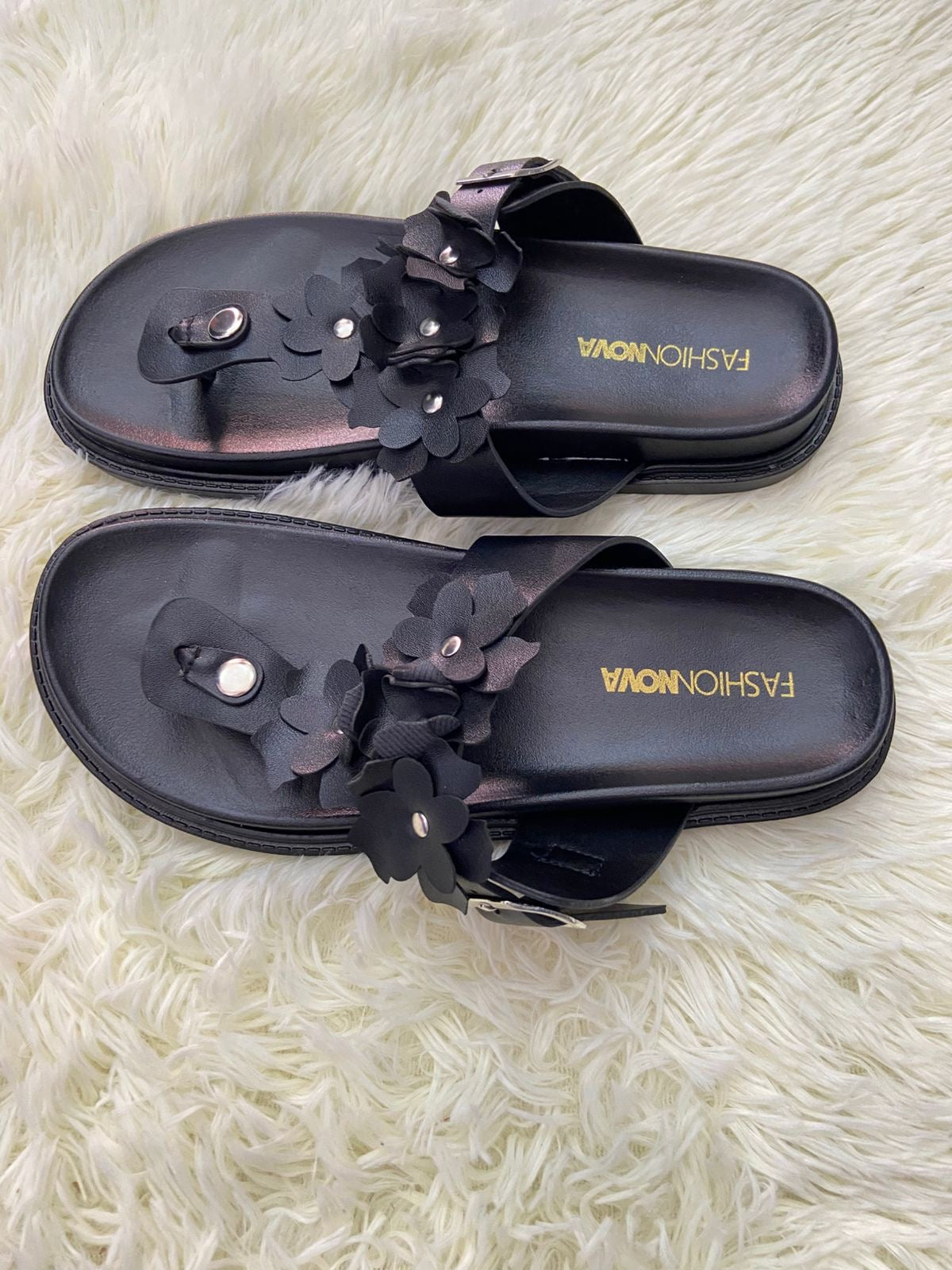Sandalias, negra con flores en frente y correa ajustable.