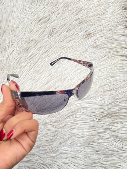 Lentes diseñados con protección UV 100-400 para proteger tu visión. Negros con montura fina y estampado animal print