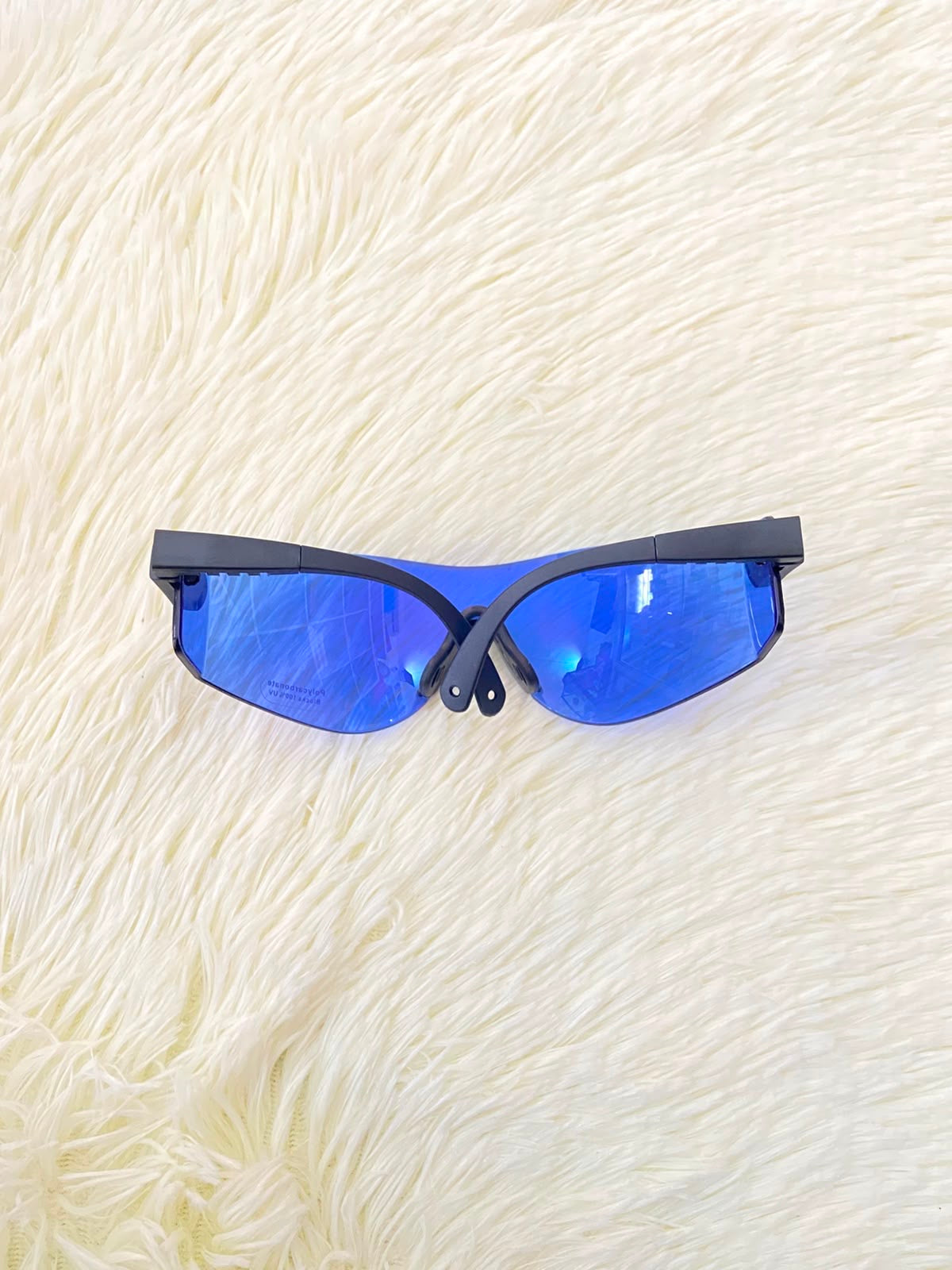 Lentes, sin montura con micas en color azul y patillas negras.