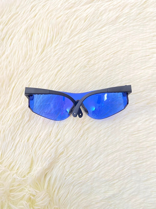 Lentes, sin montura con micas en color azul y patillas negras.