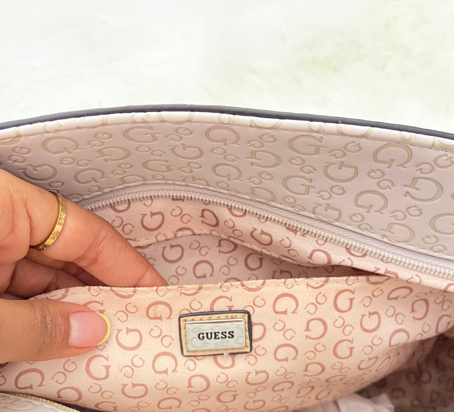Cartera GUESS original, grande, rosado palo crema con letras G y placa GUESS en plateado en frente.