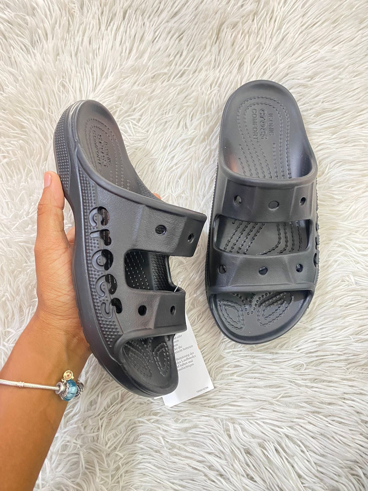 Sandalias Crocs original negra con letras de la marca al lado.