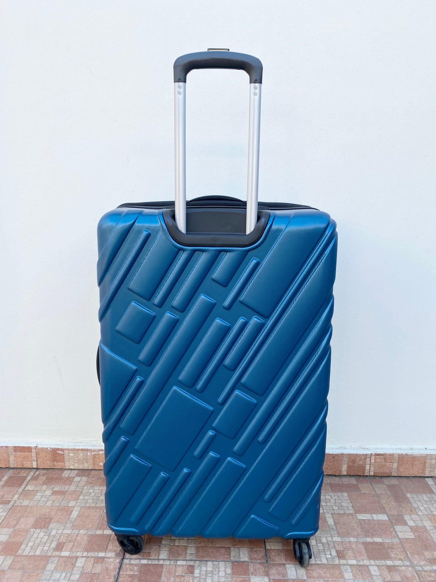 Maleta American Tourister original azul con negro y placa de la marca en frente.