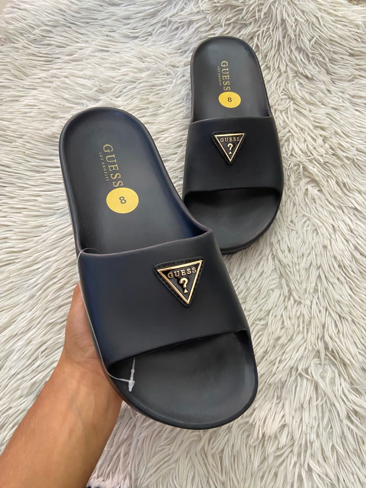 Sandalias GUESS original, negra con plataformas y placa GUESS en frente en color dorado y negro.